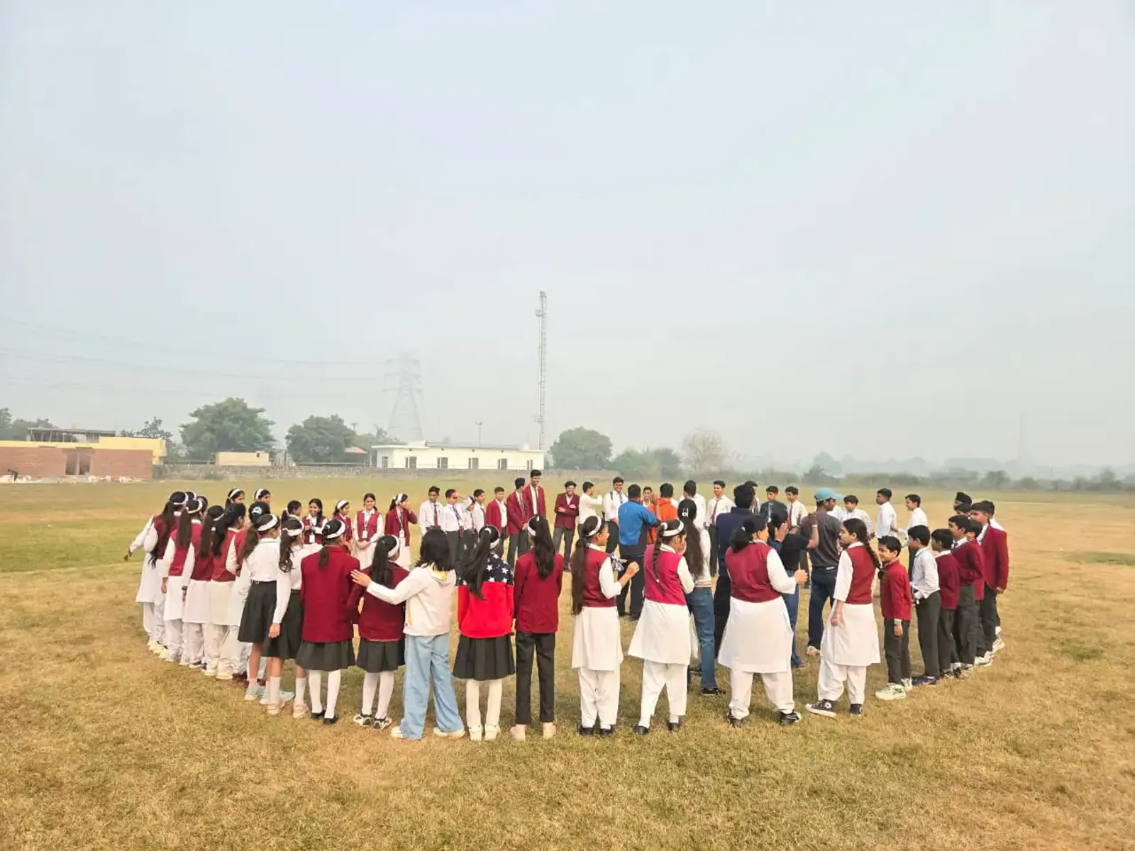 Large school group gathered in a circle on the field