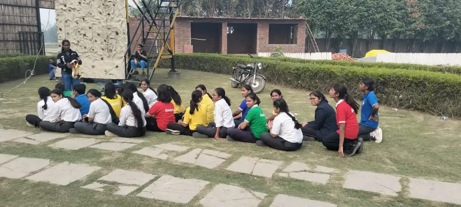 Students seated on the lawn between adventure activities at Veda Adventures