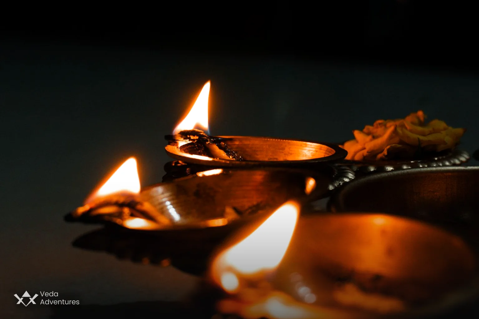 Lit brass diyas and marigold flowers for Diwali