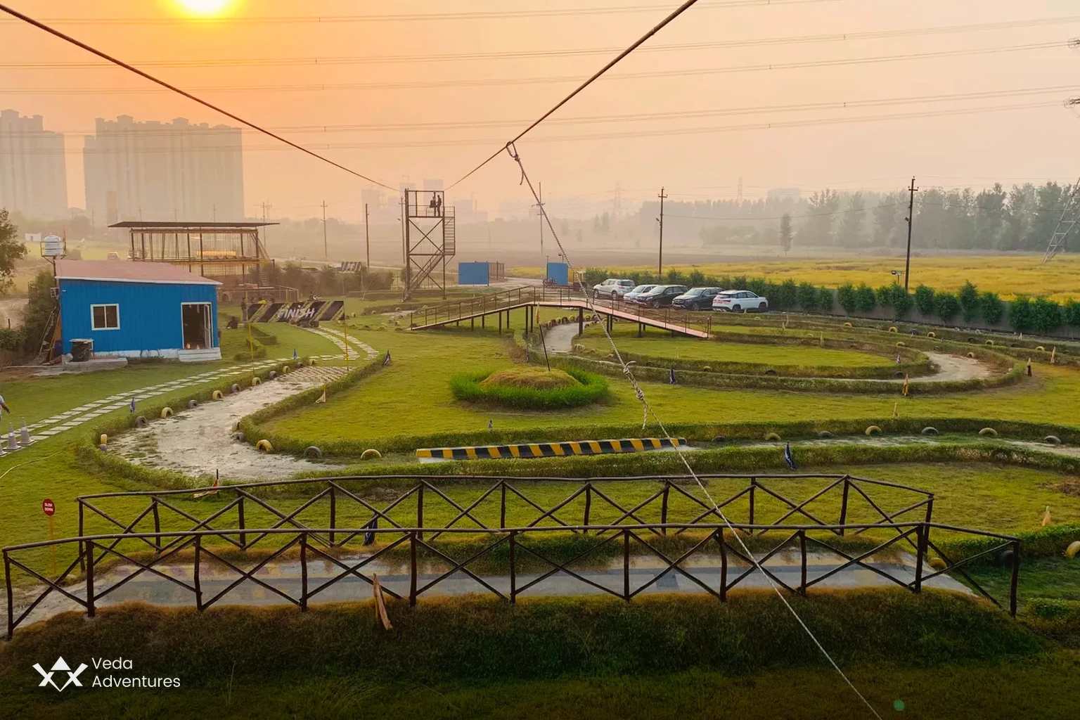 Sunset view over the lawns, rope course and zipline at Veda Adventures Park